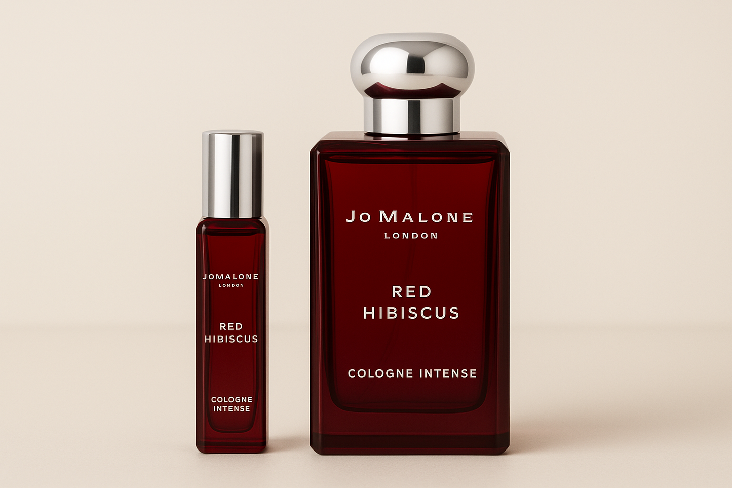 Jo Malone 红木槿古龙水 12ml 样品放在 Jo Malone 红木槿古龙水 100ml 香水瓶旁边,深红色瓶身上有白色字样